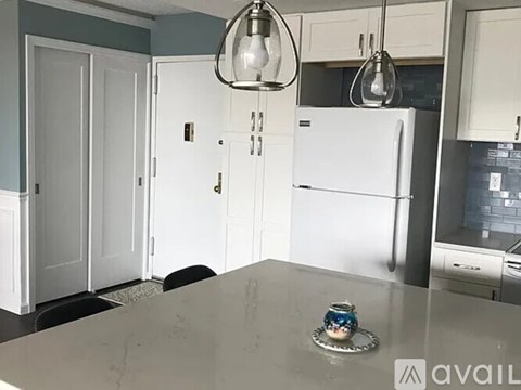 A kitchen with a white fridge and cabinets.