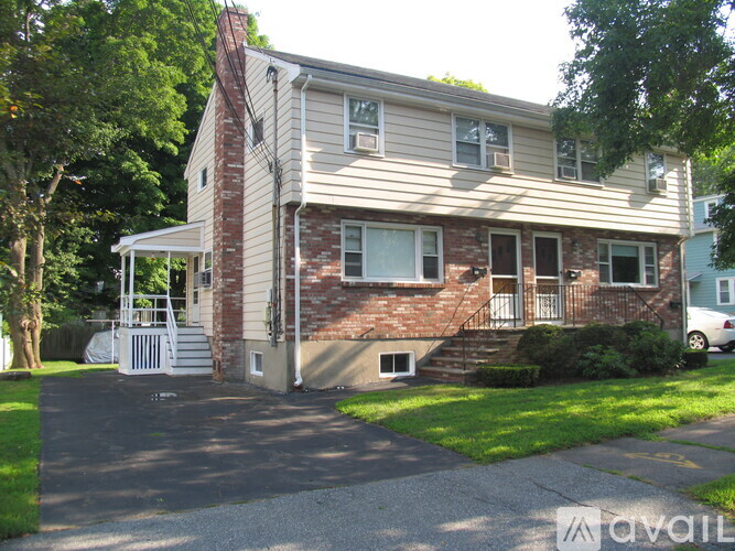 A two-story house with a brick chimney and a white garage door.