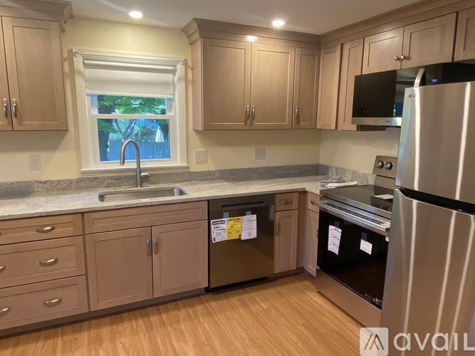 A kitchen with wooden cabinets and a black refrigerator.
