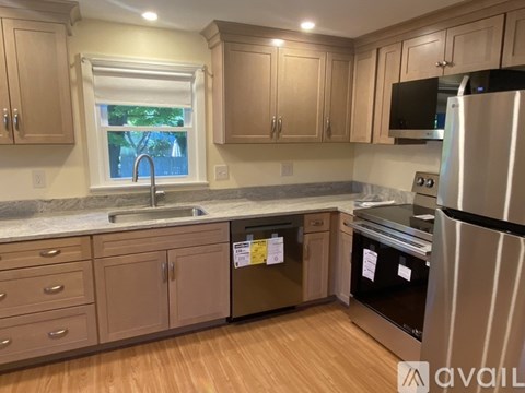 A kitchen with wooden cabinets and a black refrigerator.