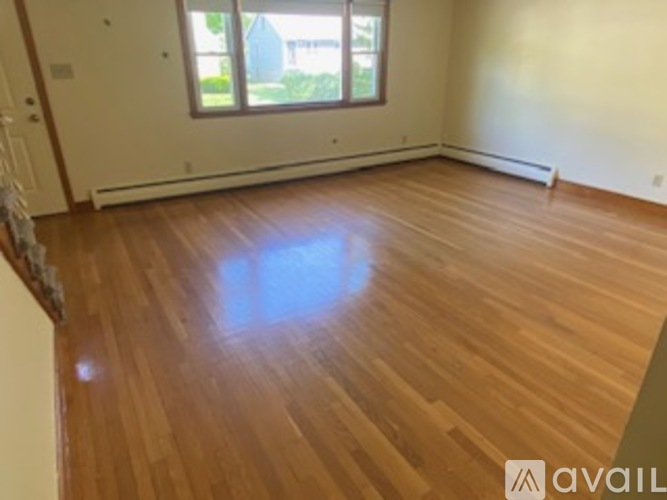 A room with wooden flooring and a window.