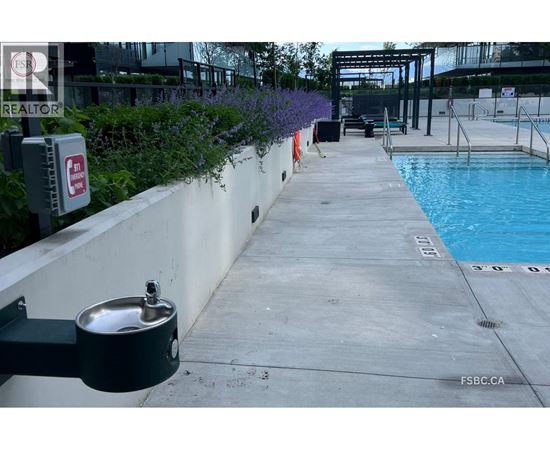 A pool area with a diving board and a pool ladder.