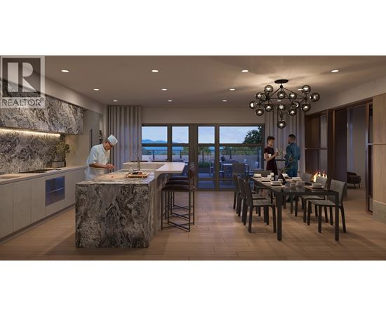 A modern kitchen with a marble island and a dining table set for two.