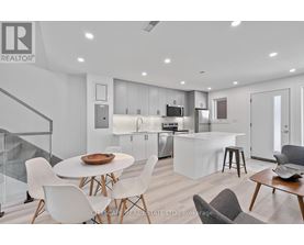 A modern kitchen with white chairs and a glass table.