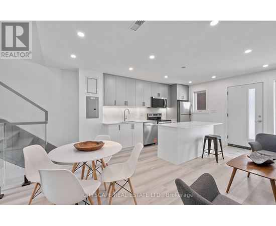 A modern kitchen with white chairs and a glass table.