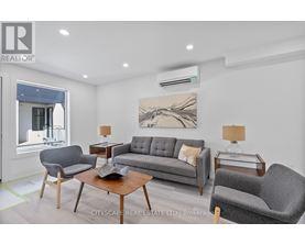 A living room with a grey couch, two armchairs, a coffee table, and a painting on the wall.
