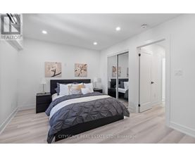 A bedroom with a large bed and a painting on the wall.