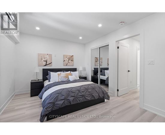 A bedroom with a large bed and a painting on the wall.