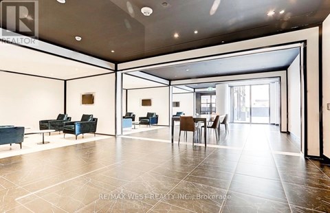 A spacious living room with a dining area and a kitchen in the background.
