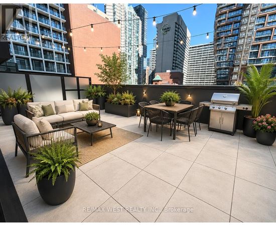 A patio with a table, chairs, and potted plants.