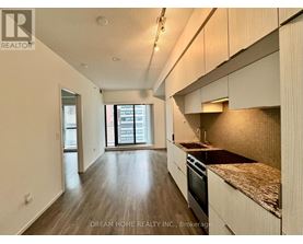 A kitchen with wooden floors and a countertop with a sink.