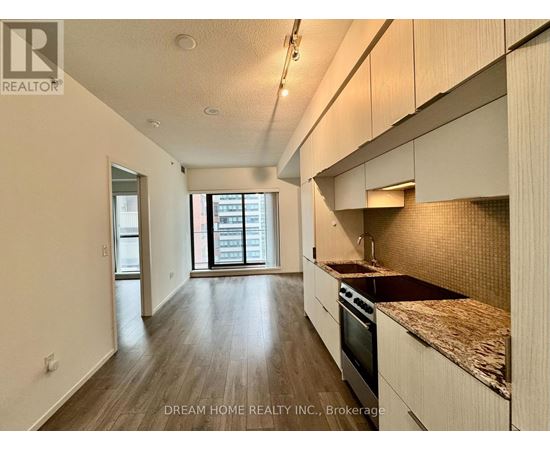 A kitchen with wooden floors and a countertop with a sink.