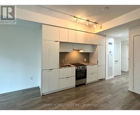 A kitchen with white cabinets and a stove top oven.