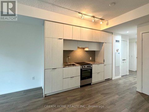 A kitchen with white cabinets and a stove top oven.