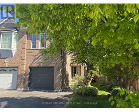 A house with a garage and a tree in front.