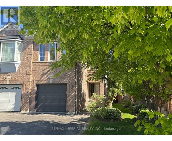 A house with a garage and a tree in front.
