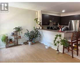 A kitchen with a wooden floor and a white wall.