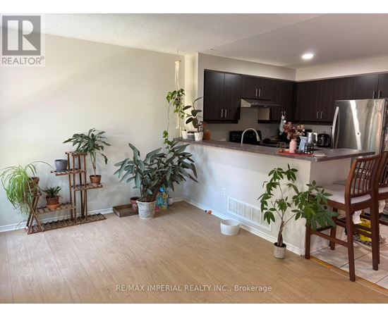 A kitchen with a wooden floor and a white wall.