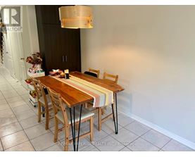 A dining room with a wooden table and chairs.