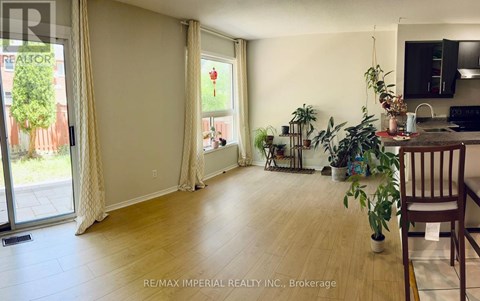 A living room with a sliding glass door and a dining area with a table and chairs.
