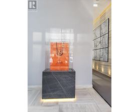 A modern art piece is displayed in a glass case.
