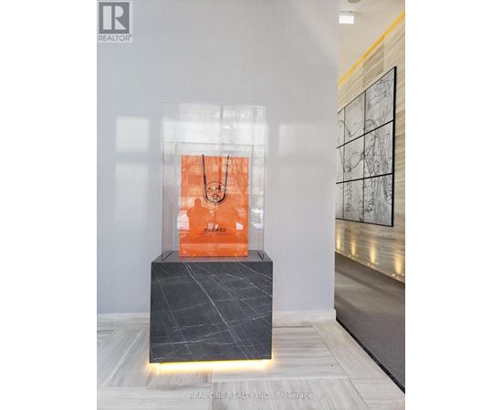 A modern art piece is displayed in a glass case.