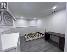 A bedroom with a bed, a desk, and a whiteboard.