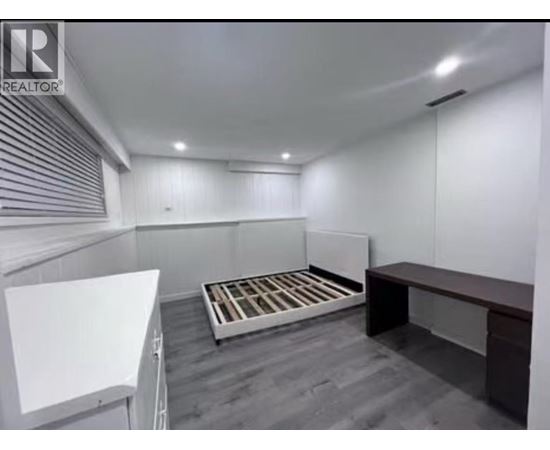 A bedroom with a bed, a desk, and a whiteboard.