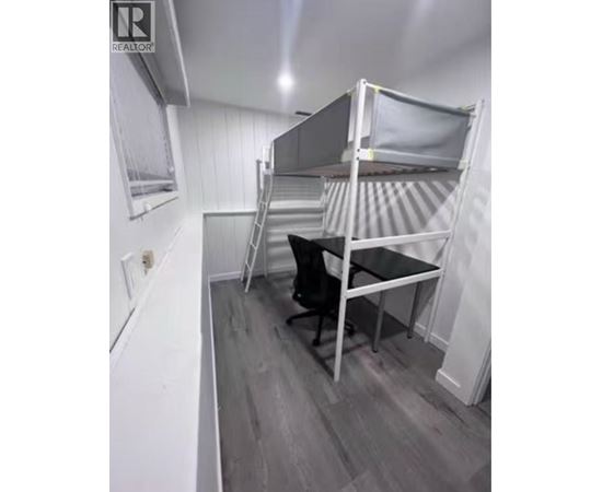 A small room with a bunk bed and a desk.