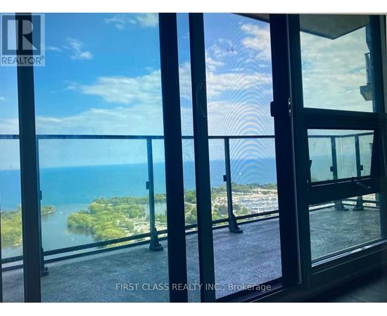 A glass door with a view of a body of water and land beyond.