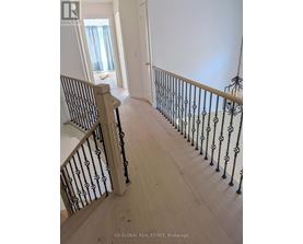 A staircase with a black railing and wooden steps.
