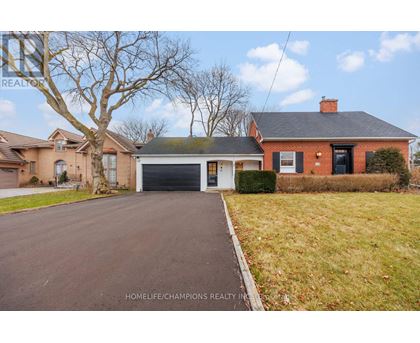 A red brick house with a black garage door in front.