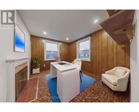 A realtor's office with a fireplace and a painting on the wall.