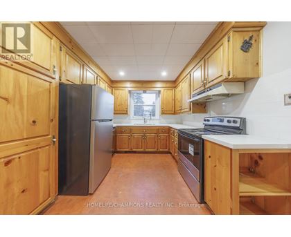 A kitchen with wooden cabinets and a refrigerator.