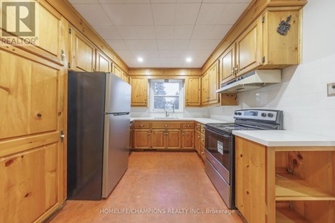 A kitchen with wooden cabinets and a refrigerator.