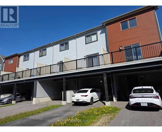 A white car is parked in the garage of a multi-story apartment building.