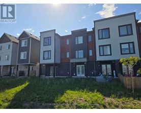 A row of modern townhouses with a grassy area in front.
