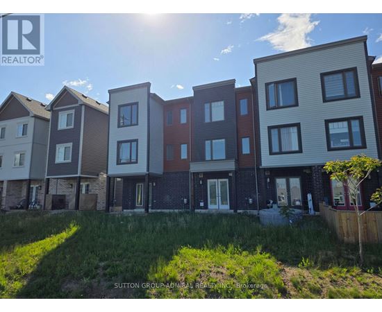 A row of modern townhouses with a grassy area in front.