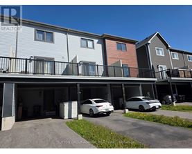 A row of townhouses with cars parked in the garages.