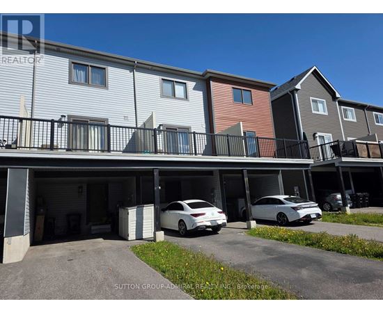 A row of townhouses with cars parked in the garages.