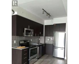 A kitchen with a black counter top and stainless steel appliances.