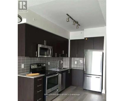 A kitchen with a black counter top and stainless steel appliances.
