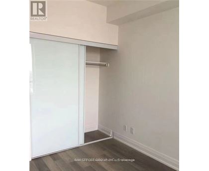 A room with a sliding door and a white wall.