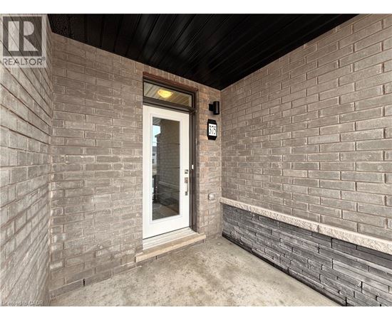A door with a glass window is in a room with brick walls.