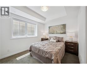 A bedroom with a bed, nightstands, and a window.