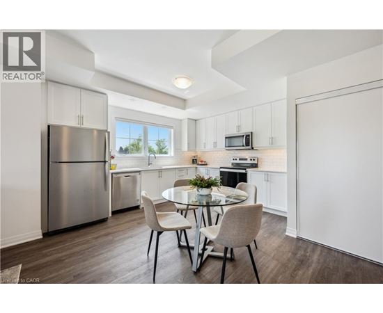 A modern kitchen with a dining table set for two.