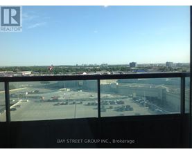 A view from a window of a parking lot and buildings.
