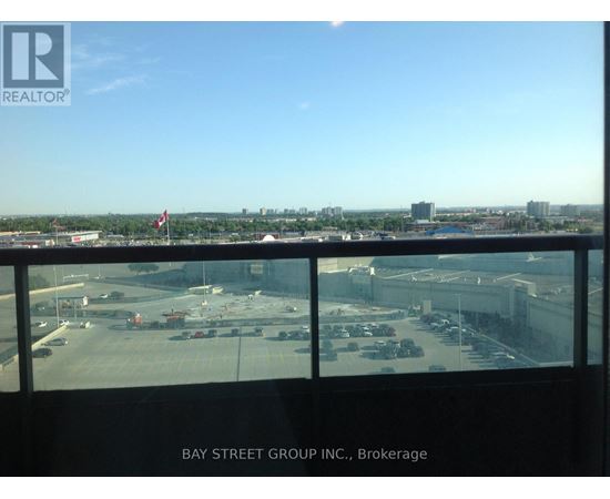 A view from a window of a parking lot and buildings.