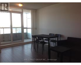 A dining area with a table and chairs in front of a sliding glass door.