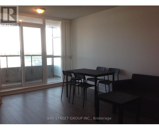 A dining area with a table and chairs in front of a sliding glass door.